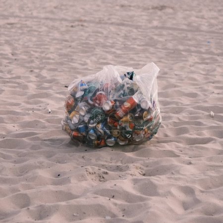 Photo for A stark reminder of environmental challenges, this image showcases a bag of discarded cans on a Brazilian beach. Highlighting the urgent need for pollution control, the solitary bag against the backdrop of the beach's natural beauty serves as a call - Royalty Free Image