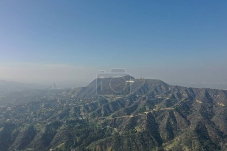 Photo for The sprawling Hollywood Hills bask in the sun, with the world-famous Hollywood sign standing prominently amidst the greenery, a testament to the city's cinematic glory, captured from a drone's perspective. - Royalty Free Image