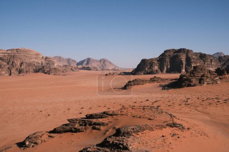 Téléchargez les photos : This image showcases the expansive beauty of the Jordanian Wadi-Rum desert, with its wide-open spaces punctuated by majestic rocky outcrops, inviting viewers to explore the untouched and rugged landscapes of the Middle East. - en image libre de droit