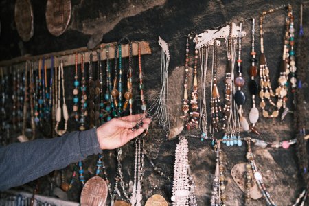 Téléchargez les photos : A hand explores the array of traditional Bedouin jewelry displayed in Petra, with each bead and ornament reflecting the rich cultural heritage and artisanal craftsmanship of Jordan's nomadic tribes. - en image libre de droit