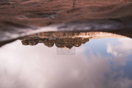 Photo for In the heart of Jordan's rocky desert, a serene puddle reflects the clear blue sky, creating a moment of tranquility and reflection amidst the arid landscape. - Royalty Free Image