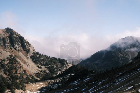 Photo for The first light of day reveals Spain's rugged valleys, their slopes and trees partly veiled in mist, offering a scene of natural tranquility and the promise of solitude. - Royalty Free Image