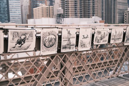 Photo for Artistic impressions of New York City's iconic scenes are displayed on a bridge, offering pedestrians a gallery-like experience amidst the urban hustle. - Royalty Free Image
