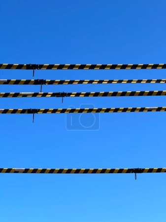 Téléchargez les photos : A minimalist composition of yellow and black striped urban barriers against a vivid blue sky captures the essence of city life and urban design in Sydney, Australia. Ideal for themes of restriction, urban planning, or minimalist art, this image conve - en image libre de droit
