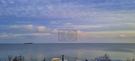 Foto de La nave se mueve a lo largo del horizonte.Las nubes se reflejan maravillosamente en la superficie lisa del mar. - Imagen libre de derechos