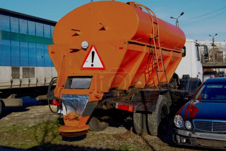 Téléchargez les photos : Equipement routier spécial.Un camion orange vif pour épandre du sable ou du sel sur la route. - en image libre de droit