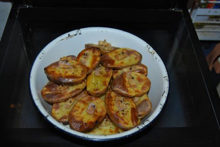 Baked potatoes in the oven.Ruddy potatoes with a piece of lard on a match. A very tasty dish.