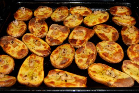 Baked potatoes in the oven.Ruddy potatoes with a piece of lard on a match. A very tasty dish.
