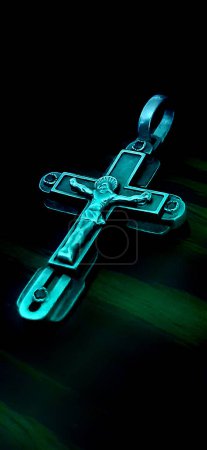 Body-worn cross with crucifix.The cross is located in the center on a black background.