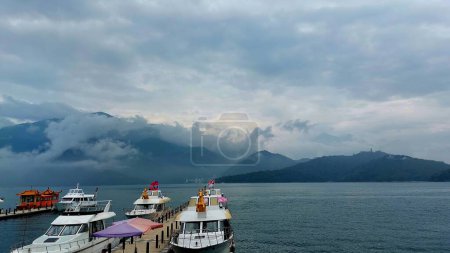 scenic photo of boat on lake with mountain and sky background