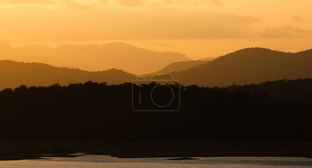Téléchargez les photos : Coucher de soleil sur un lac dans un paysage tropical - en image libre de droit