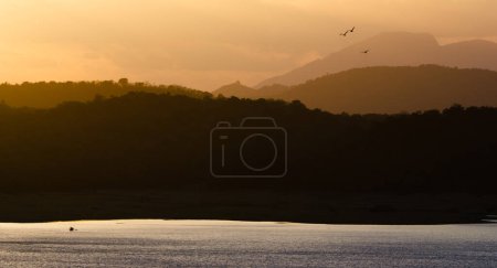 Téléchargez les photos : Coucher de soleil sur un lac dans un paysage tropical - en image libre de droit