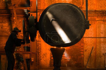 Téléchargez les photos : Métallurgiste versant du métal fondu chaud dans un moule - en image libre de droit