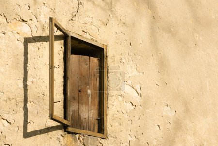 Foto de Persiana de madera envejecida en fachada descuidada - Imagen libre de derechos