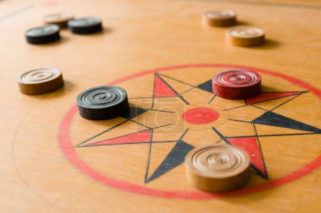 Foto de Un juego de carrom con piedras dispersas en el tablero alrededor de la estrella central - Imagen libre de derechos