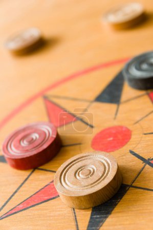 Foto de Un juego de carrom con piedras dispersas en el tablero alrededor de la estrella central - Imagen libre de derechos