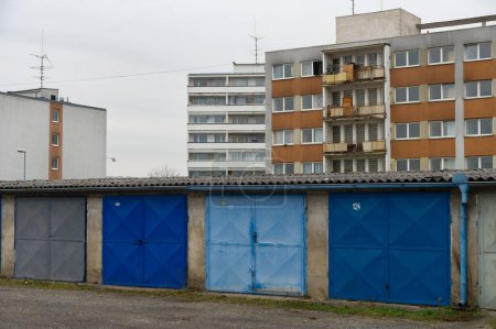 Weathered garages by communist style prefabricated concrete apartment houses