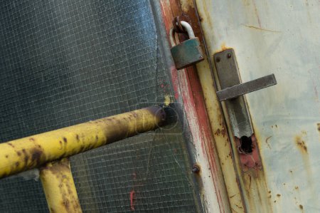 Téléchargez les photos : Porte fermée et verrouillée dans une zone industrielle abandonnée - en image libre de droit