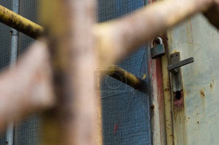 Téléchargez les photos : Porte fermée et verrouillée dans une zone industrielle abandonnée - en image libre de droit