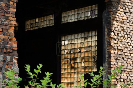 Téléchargez les photos : Dépôts endommagés et poussiéreux dans une fenêtre d'un bâtiment industriel abandonné - en image libre de droit