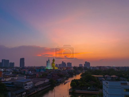 Photo for .aerial view golden big Buddha Wat Paknam Phasi Charoen in sunset. .beautiful sunset reflection on a canal in front big buddha. .scenery sky in twilight background.the one famous landmarks in Thailand.. - Royalty Free Image