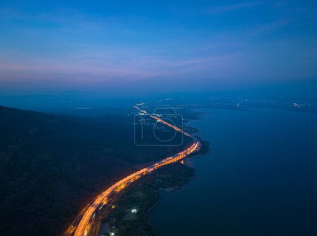 Téléchargez les photos : Vue aérienne lumières orange sur l'autoroute le long de la route le long de la Lam Ta Khong Dam.beau paysage dans le moulin à vent tôt le matin sur les montagnes, les rivières et le ciel doux fond. - en image libre de droit