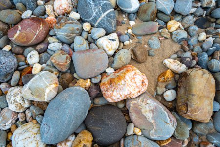 Foto de Increíble ver en la playa está lleno de rocas redondas en lugar de arena. rocas redondas tienen hermoso color y varios tamaños. rocas playa en el monumento del faro de la isla de Lanta Krabi. fondo de piedra. - Imagen libre de derechos