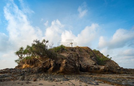 Téléchargez les photos : L'île où se trouve le phare Il y a une formation rocheuse inhabituelle avec des pierres rondes colorées de différentes tailles remplissant la plage ci-dessous. - en image libre de droit