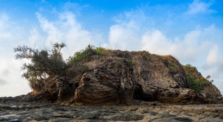 Téléchargez les photos : L'île où se trouve le phare Il y a une formation rocheuse inhabituelle avec des pierres rondes colorées de différentes tailles remplissant la plage ci-dessous. - en image libre de droit
