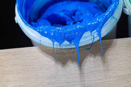 Foto de Pintura azul goteando del barril blanco - Imagen libre de derechos