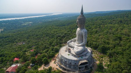 Foto de .vista aérea Gran estatua de buda blanca en la montaña para la gente tailandesa visita de viaje y respeto. Rezar en Wat Roi Phra Phutthabat Phu Manorom el 15 de mayo de 2017 en Mukdahan, Tailandia. Fondo del río Kong.. - Imagen libre de derechos