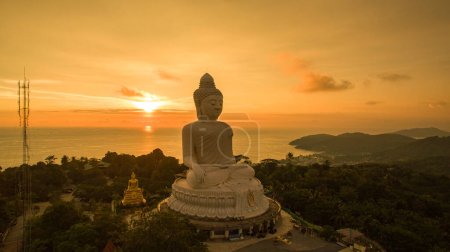 Aerial view Phuket big Buddha in beautiful sunset.amazing sun shines through the yellow clouds impact on golden sea surfaceThe beauty of the statue fits perfectly with the charming nature.