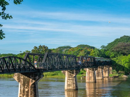 Téléchargez les photos : Le train passe par le pont ferroviaire de la mort sur la rivière Kwai à Kanchanaburi. Pendant la Seconde Guerre mondiale, le Japon a construit un chemin de fer entre la Thaïlande et la Birmanie.. - en image libre de droit