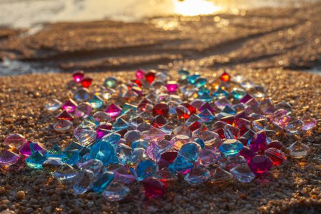 Foto de Diamantes coloridos esparcidos por la playa El sol brillaba en las facetas de las piedras preciosas - Imagen libre de derechos