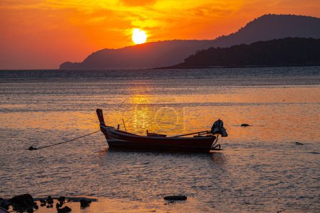 Foto de Asombroso cielo amarillo del amanecer sobre la isla, estacionamiento del barco de pesca en el mar de oro. - Imagen libre de derechos