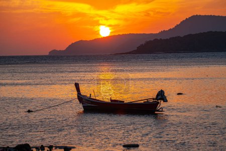 Téléchargez les photos : Ciel jaune incroyable du lever du soleil au-dessus de l'île, parking bateau de pêche sur la mer dorée. - en image libre de droit