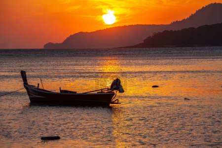 Foto de Asombroso cielo amarillo del amanecer sobre la isla, estacionamiento del barco de pesca en el mar de oro. - Imagen libre de derechos
