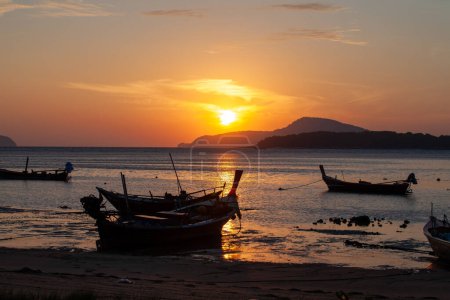 Téléchargez les photos : Ciel jaune incroyable de lever de soleil au-dessus de l'île, bateaux de pêche parking sur la mer dorée - en image libre de droit