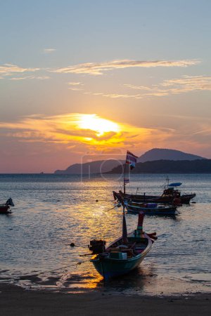 Foto de Increíble cielo amarillo del amanecer sobre la isla, barcos de pesca aparcamiento en el mar de oro - Imagen libre de derechos