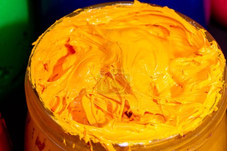Photo for Close up yellow color of ink for print tee shirt in the transparent glass bucket - Royalty Free Image