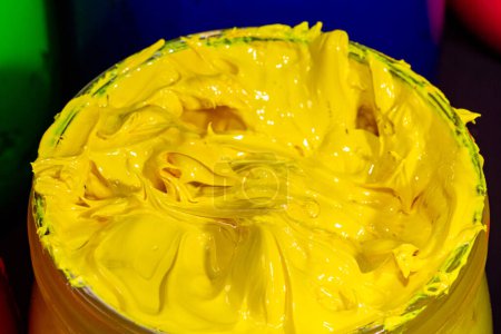 Photo for Close up yellow color of ink for print tee shirt in the transparent glass bucket - Royalty Free Image