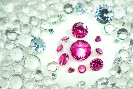 Foto de Las piedras preciosas rosadas se muestran sobre un fondo blanco girando a su derredor. Los diamantes rosados de varios tamaños y formas se muestran en el centro de los diamantes blancos. - Imagen libre de derechos