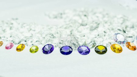 Foto de Diamantes coloridos de varios tamaños se colocan en un círculo central sobre fondo de diamantes blancos - Imagen libre de derechos