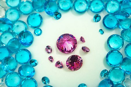 Foto de Grupo de diamantes rosados dispuestos en medio de diamantes azules sobre un fondo blanco - Imagen libre de derechos