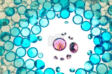 Téléchargez les photos : Groupe de diamants roses disposés au milieu de diamants bleus sur un fond blanc - en image libre de droit