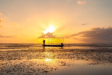 Foto de Un pescador en el barco en el impresionante amanecer amarillo en la laguna Talay Noi, Tailandia - Imagen libre de derechos