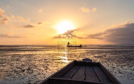 Téléchargez les photos : Un pêcheur sur le bateau dans un magnifique lever de soleil jaune au lagon Talay Noi, Thaïlande - en image libre de droit