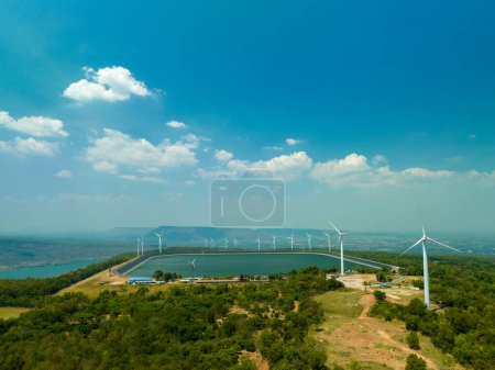 Téléchargez les photos : Vue aérienne nuage blanc dans le ciel bleu au-dessus de l'éolienne sur le sommet de la montagne au coucher du soleil dans le barrage de Lam Takong, Nakhon Ratchasima, Thaïlande. Énergie propre. fond bleu ciel. - en image libre de droit
