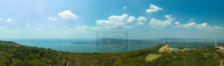 Foto de Vista aérea nube blanca en el cielo azul por encima de la turbina eólica en la cima de la montaña al atardecer en la presa de Lam Takong, Nakhon Ratchasima, TailandiaLa energía eólica genera electricidad. Energía limpia. fondo cielo azul. - Imagen libre de derechos