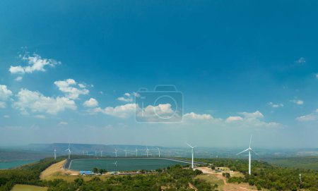 Photo for Aerial view white cloud in blue sky above wind turbine on the top of mountain at sunset in Lam Takong Dam, Nakhon Ratchasima, ThailandWind power generates electricity. Clean energy. blue sky background. - Royalty Free Image